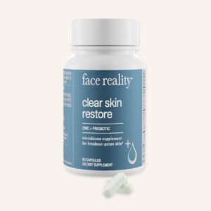 Face Reality clear skin restore supplements product with white pills in front on a light grey background.